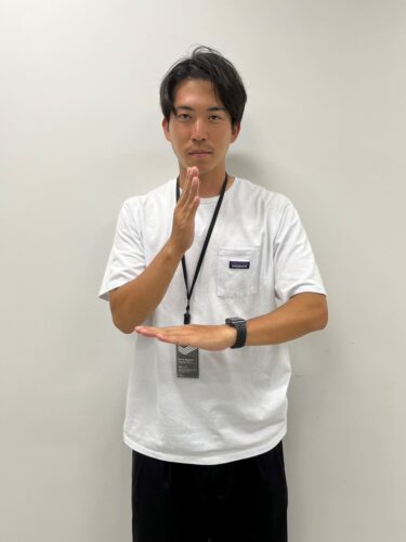 三枝浩基コーチが手話で「ありがとう」を表現しています。